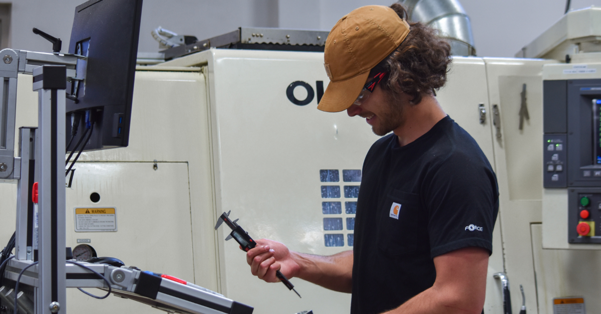 Entry-level operator inspects parts as they come off a CNC lathe